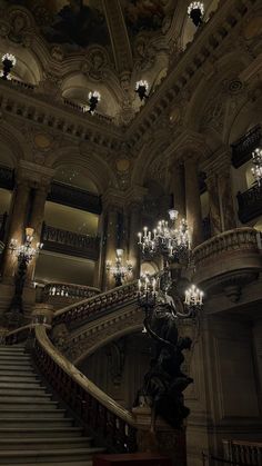 the chandeliers are hanging from the ceiling above the stairs in an ornate building