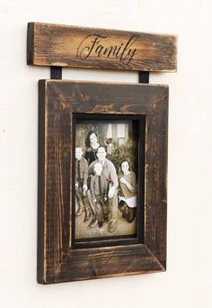 an old family photo hanging on a wall with the word family written in cursive font