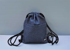 a small blue bag sitting on top of a white table next to a gray wall