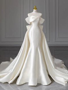 a white wedding dress on display in a room