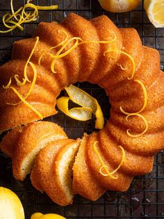 a bundt cake with lemons and orange slices on a cooling rack next to it