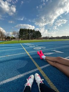 a person laying on the ground with their feet propped up in front of an empty running track