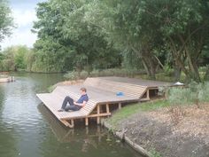 a man sitting on top of a wooden dock