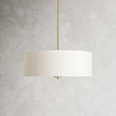 a white lamp hanging from a ceiling in a room with concrete walls and flooring