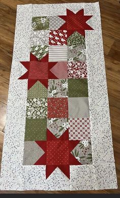 a quilted table runner with red and green stars on it