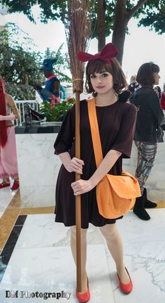 a woman dressed as a witch holding a broom