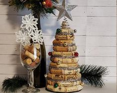 a wine cork christmas tree next to a bottle of wine and a glass filled with champagne