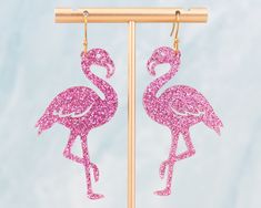 These light-weight acrylic flamingo earrings are the perfect statement earrings to add an extra pop to your outfit! Acrylic is lightweight so you can enjoy large, statement earrings comfortably all day. ♡ Made with pink glitter acrylic that doesn't flake ♡ Size: Approximately 2.75 inches in length measured from earring hook. ♡ Earring hook is made from surgical stainless steel ♡ Care Instructions: ♡ - To clean: Wipe with a microfiber cloth to remove any dust - Avoid contact with perfumes and lot Flamingo Fashion, Flamingo Earrings, Flamingo Gifts, Large Statement Earrings, Glitter Acrylic, Bold Earrings, Fun Jewelry, Earring Hook, Glitter Acrylics