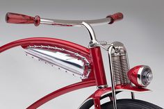 a close up of the handlebars on a red bike with chrome accents and an engine