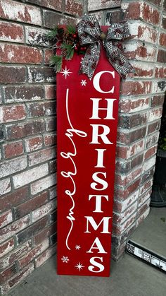 a red christmas sign hanging on the side of a brick wall