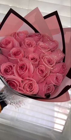 a bouquet of pink roses sitting on top of a table