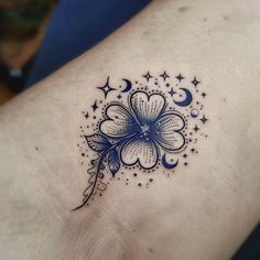 a tattoo design on the side of a woman's left arm with stars and a flower