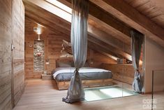 an attic bedroom with wooden walls and flooring