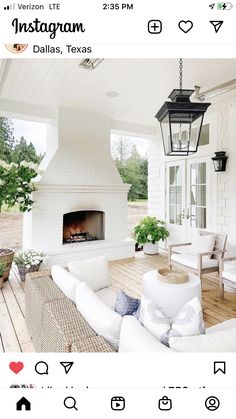 a living room with white furniture and a fire place in the center is instagramted