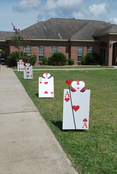 some cards are sitting in the grass near a house with a driveway and lawn behind them