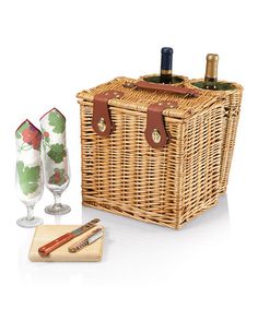 a wicker picnic basket with two wine glasses