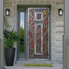 the front door is decorated with an intricate metal design and potted plant on the side