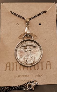 a necklace with an image of a man holding a cross on it's back