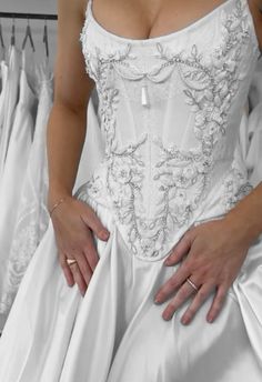 a woman in a white wedding dress with her hands on her hips