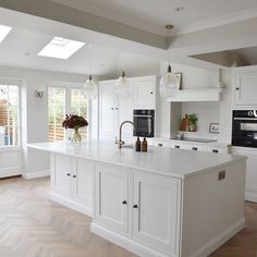 a large kitchen with white cabinets and an island