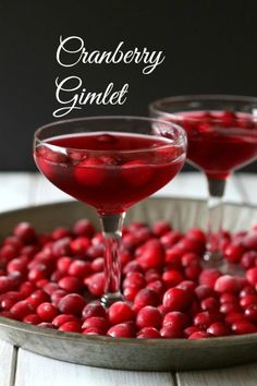 two glasses filled with cranberry martinis on top of a table