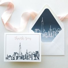 a thank you card and envelope with a city skyline