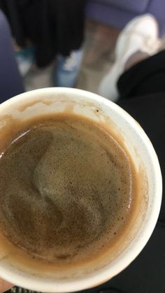 a person holding a cup of coffee in their hand