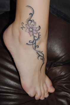 a woman's foot with a flower tattoo on it