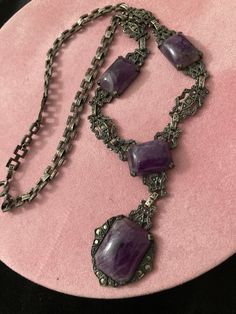 "COUPON CODE available at check out.  Antique 19th C Medieval Revival sterling amethyst stone pendant necklace. 13 marcasites dot this necklace. There are patterns within patters. Faux marcasite studs thru out. Picture frame style  filigree cut out sturdy flat solid sterling panels for bottom half of necklace.  An intricate flat square interlocking chain for the upper half. The square chain links are all intricately designed.  Back of center pendant is marked sterling.  Largest stone MEASURES:  Approx 3/4\" x 1/2\" (little more). Next 3 measure the same at approx: 1/2\" x 1/2\" (a little more.) Purple stone is freezing cold to the touch. Regular flashlight shown under light. See all photos. No cracks in any stones. Email any questions prior to purchase.  My opinion of the style might be di Collectible Spiritual Purple Necklace, Hallmarked Amethyst Pendant Necklace, Antique Engraved Purple Jewelry, Victorian Style Necklace With Oxidized Finish, Victorian Style Necklace With Oxidized Finish For Gifts, Victorian Oxidized Finish Necklace For Gift, Victorian Amethyst Gemstone Jewelry, Antique Silver Gemstone Necklace, Antique Handmade Purple Jewelry