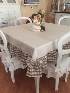 a figurine sitting on top of a table next to a white chair in a kitchen