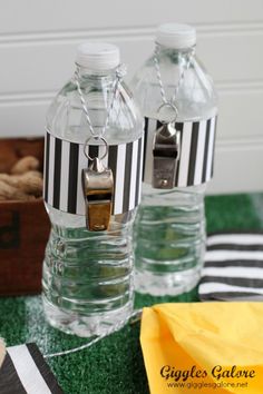 two empty water bottles sitting on top of a green table