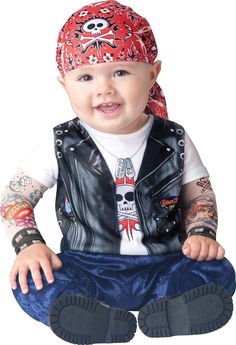 a baby sitting on the ground wearing a bandana and leather vest with skulls on it