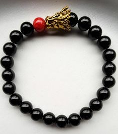 Gold color dragon head charm, black 8mm agate beads and 1 red glass bead for the fire. Beads are on an elastic cord and will fit up to a 7.5-inch wrist. Bead Dragon, Dragon Black, Fire Breathing Dragon, Fire Breathing, Dragon Head, Kansas City Mo, Bead Charm Bracelet, Agate Beads, Red Glass