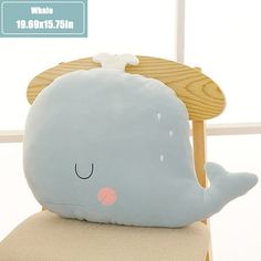 a blue whale pillow sitting on top of a wooden chair