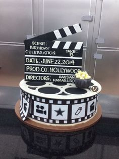 a movie themed birthday cake with popcorn and claps on it's side,