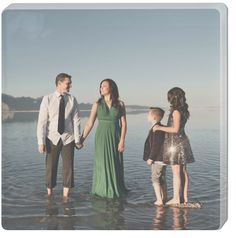 a family standing in the water holding hands