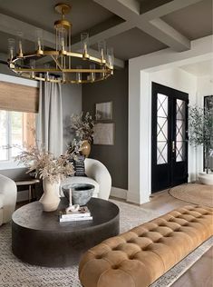 a living room filled with furniture and a chandelier hanging over it's head