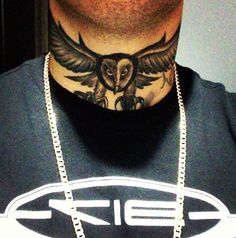 a man with an owl tattoo on his neck wearing a silver chain and a black t - shirt