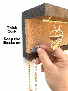 a person holding onto a wooden box with chains hanging from it's sides and the words thick cork keep the backs on