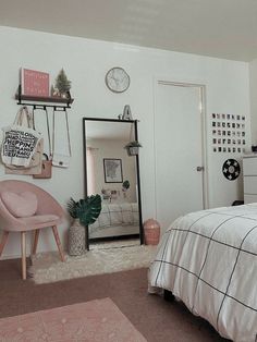 a bed room with a neatly made bed and a mirror on the wall above it