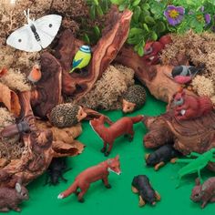 various toy animals and plants on a green surface