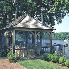 a gazebo sitting in the middle of a park next to a body of water