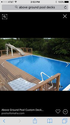 an above ground swimming pool with a slide in the middle and decking area next to it