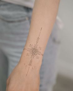 a woman's arm with a small tattoo on it