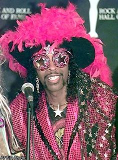 a man in pink and black costume standing next to a microphone