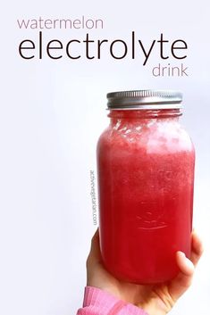 a hand holding a jar of watermelon electrolyte drink with the words, watermelon electrolyte drink