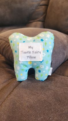 a tooth pillow that says, my tooth fairy pillow on the back of a couch