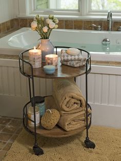 a bath tub with candles and towels on it