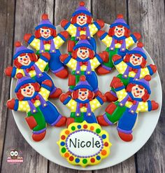 a white plate topped with cookies covered in icing and clowns on top of it