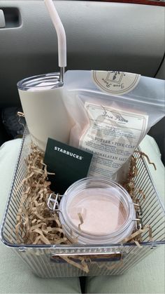 a basket filled with items sitting on top of a car seat next to a cup